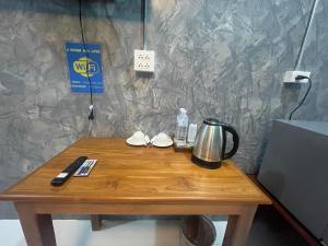 a wooden table with a coffee maker and a kettle on it at J House Has love in Sukhothai