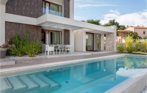 a house with a swimming pool in front of a house at Villa Adoral in Labin