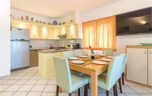 a kitchen with a wooden table and blue chairs at Nice Apartment In Stinjan in Štinjan