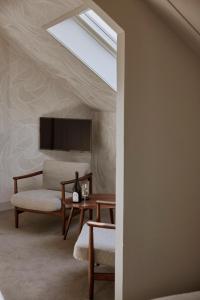 a living room with a skylight and a chair and a table at Hotel Oostergoo in Grou