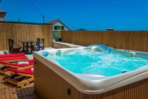 a large bath tub sitting on top of a patio at Ankora apartments sea and Old Town view - HOT TUB in Dubrovnik +16 photos