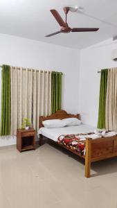 a bedroom with a bed and a ceiling fan at Vintage villa in Varkala