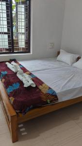 a bed with a blanket on top of it at Vintage villa in Varkala