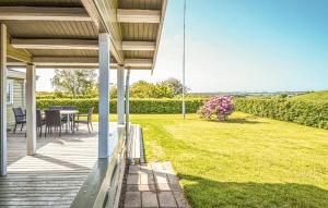 eine Veranda eines Hauses mit einem Tisch und Stühlen in der Unterkunft Holiday Home Skonnertvej Ebeltoft Xii in Ebeltoft