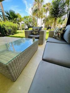 a patio with wicker chairs and a table and a pool at villa pour location vacances in Tamaris