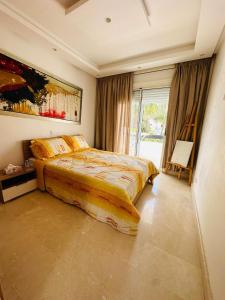a bedroom with a bed and a painting on the wall at villa pour location vacances in Tamaris +21 photos
