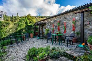 a patio with tables and chairs in a garden at Loureiro in Vega de Logares