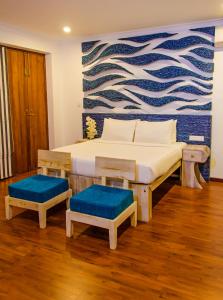 a bedroom with two beds and a painting on the wall at Binnacle Negombo in Negombo