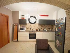 una cucina con mobili bianchi e un frigorifero di InCorteDaFabio Design flat with Bikes a Caronno Pertusella