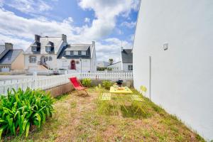 a yard with a table and chairs in front of a house at À 300m de la Greve Blanche - Appartement pour 6 in Le Guilvinec