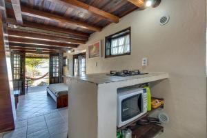 a kitchen with a counter with a tv in a room at Pousada dos Ingleses in Bombinhas