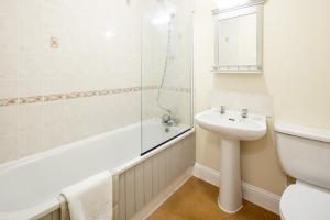 ein weißes Badezimmer mit Waschbecken und Dusche in der Unterkunft The Uplands Apartments in Saint Helier Jersey + 16 Fotos