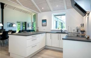 a kitchen with white cabinets and a black counter top at Stunning Home In Hjørring With Wifi in Hjørring
