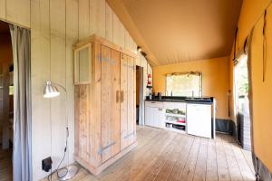 una cucina con pavimento in legno e porta in legno di Glamping Haure-Loire a Sainte-Sigolène