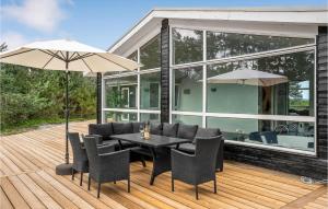 a patio with a table and chairs and an umbrella at Awesome Home In Ebeltoft With Sauna in Ebeltoft +27 photos