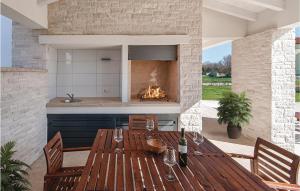 a dining room with a table and a fireplace at Amazing Home In Valbandon in Fondole