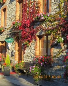 Salmchâteau的住宿－諾德薩德住宿加早餐酒店，坐在鲜花盛开的建筑前的长凳