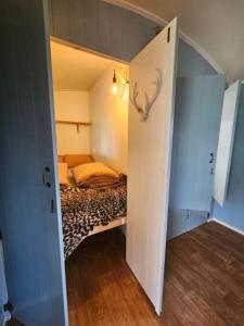 a small room with a bed in a small room at Cosy Cabin in Scharendijke