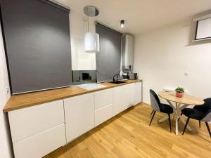 una cucina con mobili bianchi e un tavolo con sedie di Le Cin et Chic Vidéoprojecteur Popcorn Netflix a Saint-Étienne