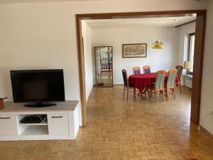 Un comedor con mesa y sillas y un televisor. en Rheinloge, en Oberwesel