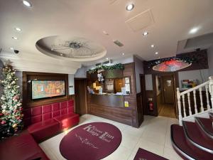a bar with a christmas tree and a red couch at Kings Cross Inn Hotel in London