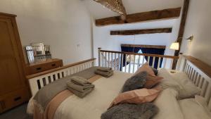 a bedroom with a bed with towels on it at Pear Tree Barns in Rangeworthy