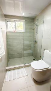 a bathroom with a glass shower and a toilet at Blue Skies on endless Beachfront in Cabarete