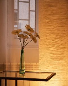 a vase with flowers sitting on a glass table at Central Luxury Cozy Modern Apartment in Sofia