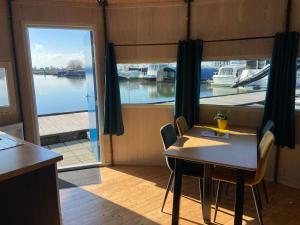 a dining room with a table and a view of a marina at Dobberhuisje in IJsselstein +23 photos