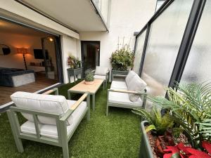 ランスにあるLe Cocon - Superbe T3 - Parking - Terrasseのバルコニー(椅子、テーブル、一部の植物付)