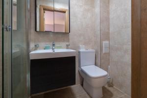 a bathroom with a toilet and a sink and a mirror at Kings Cross Inn Hotel in London