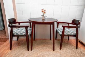 a table and two chairs with a vase on it at Ghala House Apartment Moshi in Moshi