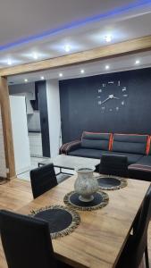 a room with a table with chairs and a couch at Ekskluzywny Apartament w Centrum z Klimatyzacją i Balkonem in Lubin