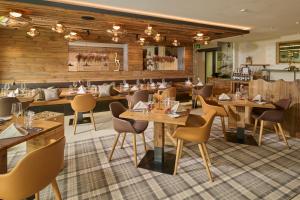 a restaurant with wooden walls and tables and chairs at Aspen Alpine Lifestyle Hotel in Grindelwald