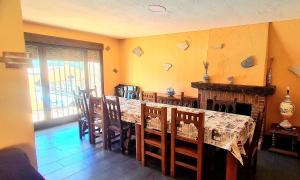 a dining room with a table and some chairs and a table and chairsktop at Casa la hijita in Navaluenga