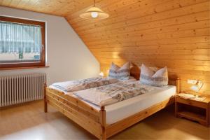 a bedroom with a bed in a wooden room at Ferienhaus Brigitte - Breitnau in Breitnau