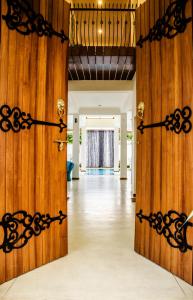 an open door into a room with wooden walls at Binnacle Negombo in Negombo