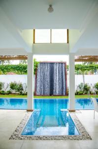 a swimming pool in a house with a window at Binnacle Negombo in Negombo