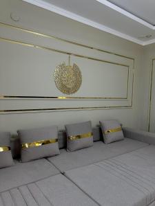 a waiting room with four pillows and a chandelier at Стильные апартаменты ближе караван сарая in Türkistan
