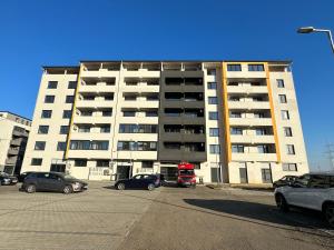 a large building with cars parked in a parking lot at Penthouse San Casa Sebeș in Sebeş