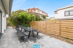 a patio with a table and a fence at Anno 2021 - Renovated coastal villa 150m from the beach in Koksijde