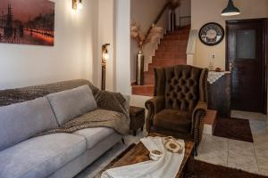 a living room with a couch and a chair at Old Town Rhapsody, Cosy 2-Floor Home with Rooftop Bathtub, BBQ & Lounge Under Sun Umbrellas in Rethymno +12 photos