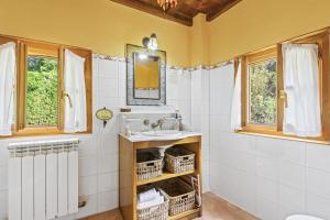 a bathroom with a sink and a mirror at Casa de Aldea La Pescal in La Pescal +28 photos