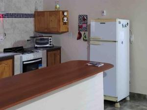 a kitchen with a white refrigerator and a stove at La rana alquiler temporal in Reyes
