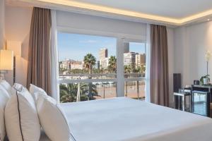a bedroom with a bed and a large window at Melia Alicante in Alicante