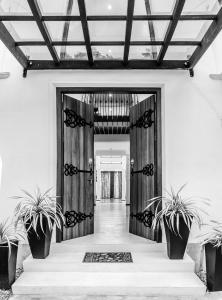 a hallway with potted plants in front of a door at Binnacle Negombo in Negombo