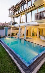 a swimming pool in front of a house at Binnacle Negombo in Negombo