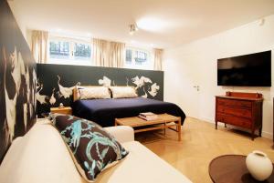a bedroom with a bed and a couch and a tv at Spacious Suite at Park and Museum in Amsterdam
