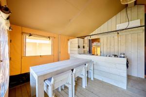a kitchen with a long wooden table in a room at Glamping Borken in Borken +30 photos