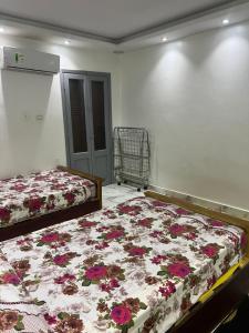 a bedroom with two beds with flowers on it at شقة في الدقي in Cairo